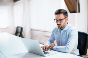 young-businessman-working-with-laptop-office - SIM Computer Dell Vostro 5630 to świetna propozycja dla firm poszukujących niezawodnych i wydajnych laptopów biznesowych